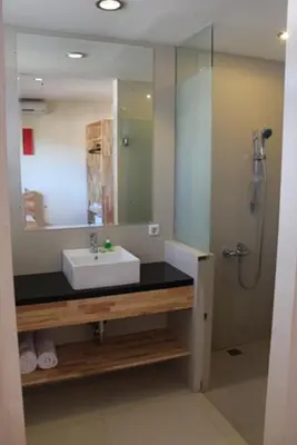 a bathroom with a sink and a mirror at Hotel Karthi Kuta in Kuta