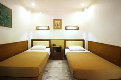 two beds in a small room with at Hotel Karthi Kuta in Kuta