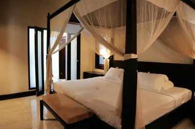 a bedroom with a bed with a canopy at The Lagoon Bali Pool Hotel and Suites in Legian