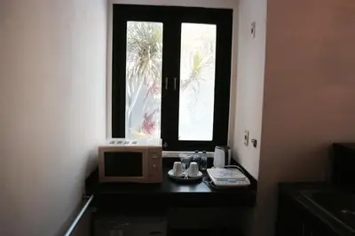 a microwave sitting on a table next to a window at The Lagoon Bali Pool Hotel and Suites in Legian