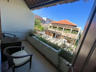 a balcony with a chair and a building at The Lagoon Bali Pool Hotel and Suites in Legian