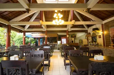 a dining room with tables and chairs in a restaurant at Bakung Sari Resort in Kuta
