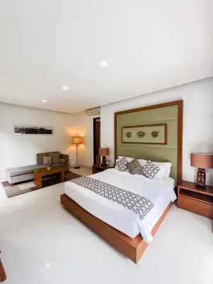 a bedroom with a large bed and a couch at Pradha Villas Seminyak in Seminyak