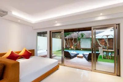 a bedroom with a bed and a balcony at Downtown Villas in Seminyak