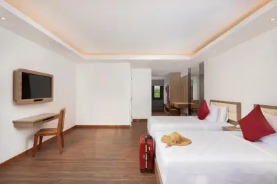 a hotel room with two beds and a television at Downtown Villas in Seminyak