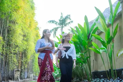 two women standing next to each other in a garden at The Maya Seminyak Villas in Seminyak