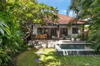 a backyard with a pool and a house at Twist and Shout Villa in Seminyak