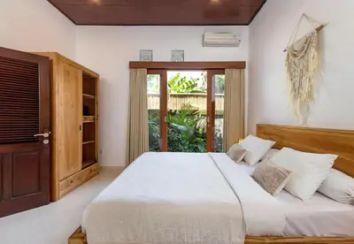 a bedroom with a large bed and a window at Twist and Shout Villa in Seminyak