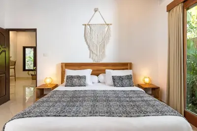 a bedroom with a large bed with two lamps at Twist and Shout Villa in Seminyak