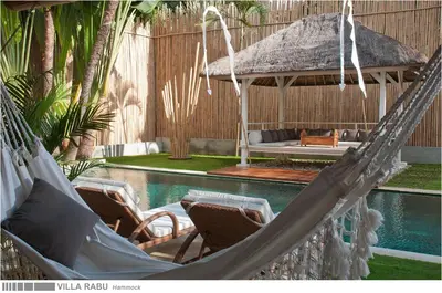 a couple of hammocks in front of a pool at 3BR Villa Rabu - Minggu Villas Seminyak in Seminyak