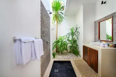 a bathroom with a sink and a shower with plants at Villa Calypso by Optimum Bali Villas in Seminyak
