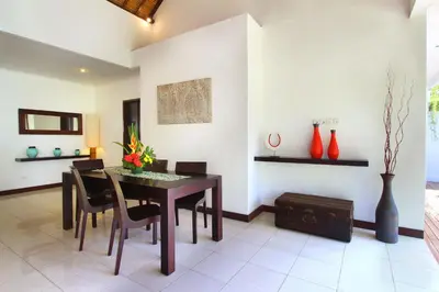 a dining room with a table and chairs at Villa Calypso by Optimum Bali Villas in Seminyak