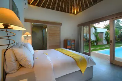 a bedroom with a bed and a pool at Villa Thiara by Optimum Bali Villas in Seminyak