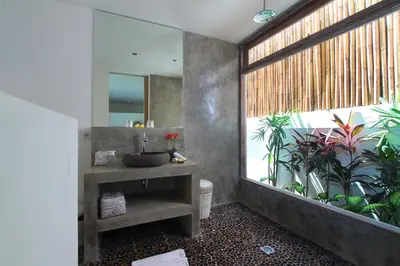 a bathroom with a sink and a mirror and plants at Villa Thiara by Optimum Bali Villas in Seminyak