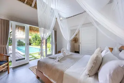 a bedroom with a white bed with a canopy at Renovated Villa Aksara Oberoi, 700m to Beach in Seminyak