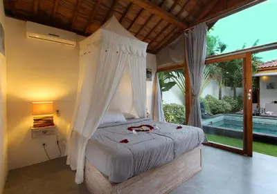 a bedroom with a bed with a canopy at Villa Tinn Tamm by Optimum Bali Villas in Seminyak