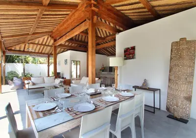 a dining room with a wooden table and white chairs at Villa Tinn Tamm by Optimum Bali Villas in Seminyak