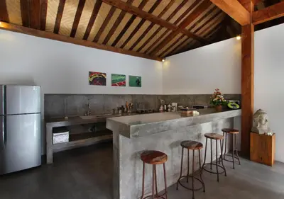 a kitchen with a large stone counter and stools at Villa Tinn Tamm by Optimum Bali Villas in Seminyak