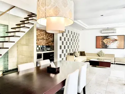 a dining room with a table and a couch at The Wangsa Benoa in Nusa Dua