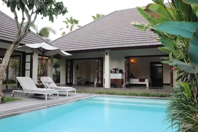 a villa with a swimming pool and a house at Nunia Boutique Villa in Seminyak
