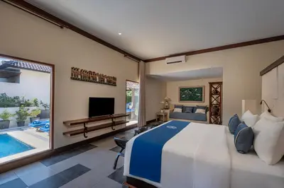a bedroom with a large bed and a swimming pool at Rama Residence Seminyak in Seminyak