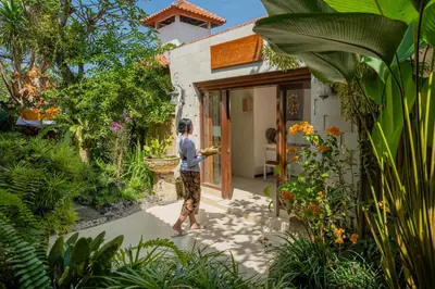 a man is standing outside of a house at Rama Residence Seminyak in Seminyak