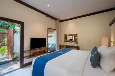 a bedroom with a large bed and a television at Rama Residence Seminyak in Seminyak