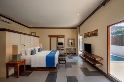 a bedroom with a large bed and a tv at Rama Residence Seminyak in Seminyak