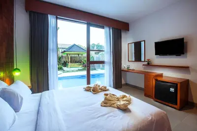 a hotel room with a bed with towels on it at Pudak Sari Unizou Hostel in Kuta