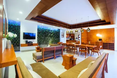 a dining room and living room with a dining table at Pudak Sari Unizou Hostel in Kuta