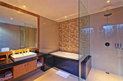 a bathroom with a tub and a sink and a shower at Lasanti Villas Seminyak in Seminyak