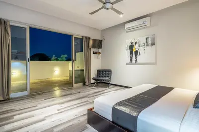a bedroom with a bed and a chair at Villa Onyx in Seminyak