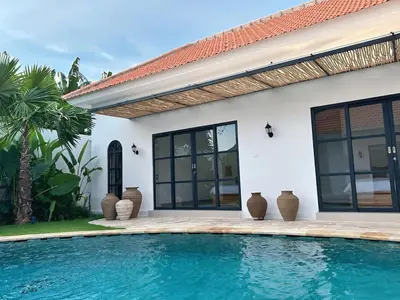 a house with a swimming pool in front of a house at Amerta Villa Seminyak in Seminyak