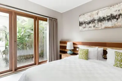 a bedroom with a white bed and a window at Dasa Villa in Seminyak