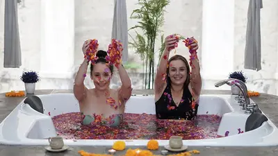 two women in a bath tub covered in confetti at Pelangi Bali Hotel & Spa in Seminyak