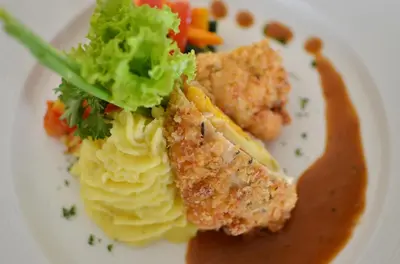 a plate of food with ravioli and meat and sauce at Pelangi Bali Hotel & Spa in Seminyak