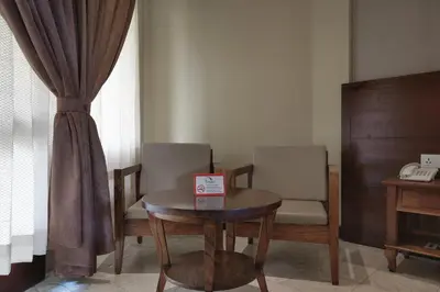 a room with a table and two chairs and a telephone at Pelangi Bali Hotel & Spa in Seminyak