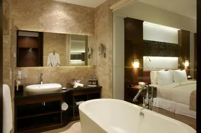 a bathroom with a tub and a bed and a sink at The Seminyak Beach Resort & Spa in Seminyak