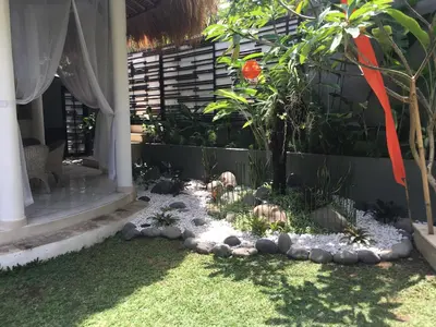 a garden with rocks and a tree in a yard at Esha Villa Umalas 2 in Kerobokan