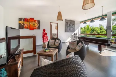 a living room with a piano and chairs at Villa Wiana by Villa Finder in Seminyak