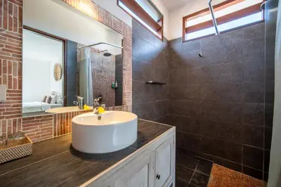 a bathroom with a sink and a mirror at Villa Wiana by Villa Finder in Seminyak