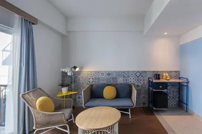 a living room with a couch and chairs and a table at Kampi Hotel Legian in Legian