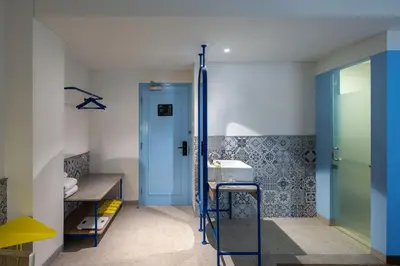 a bathroom with a sink and a blue door at Kampi Hotel Legian in Legian
