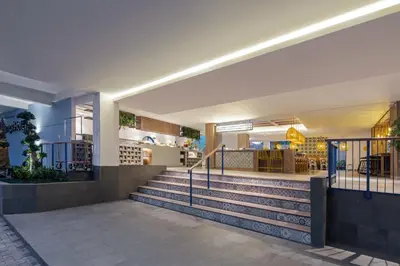 a lobby of a building with stairs and a restaurant at Kampi Hotel Legian in Legian