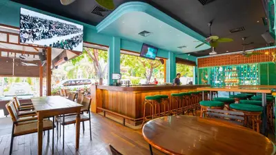 a restaurant with tables and chairs and a bar at Bali Garden Beach Resort in Kuta