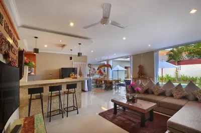 a living room and kitchen with a couch and a table at Kae Villa Anggrek in Seminyak