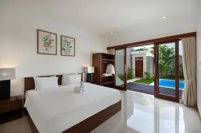 a bedroom with a bed and a large window at Daha Mansions Seminyak in Seminyak