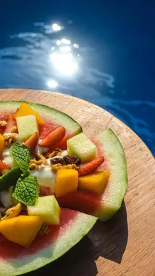 a piece of fruit on a cutting board next to a pool at Daha Mansions Seminyak in Seminyak