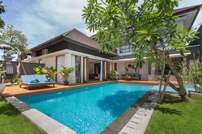 a villa with a swimming pool in front of a house at Entrada Seminyak Villa By Nagisa Bali in Seminyak