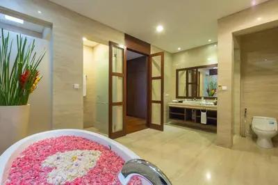 a bathroom with a bath tub filled with pink flowers at Entrada Seminyak Villa By Nagisa Bali in Seminyak